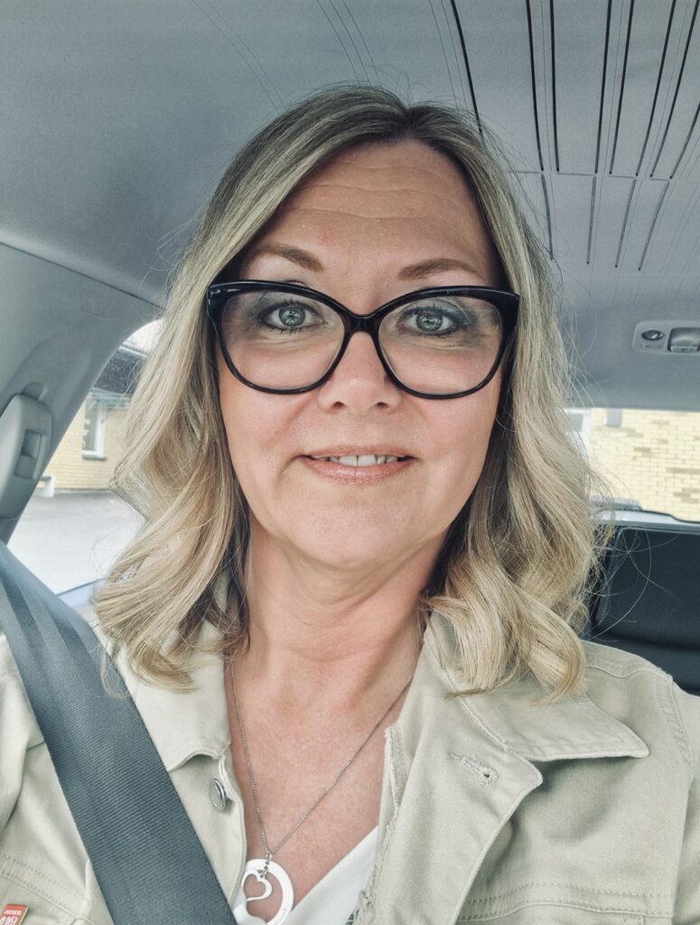 Victoria Jern Nilsson, Lokalvårdare Åsa-Linda har en uppklippt frisyr med blonda slingor och glasögon. Hon sitter i en bil och säkerhetsbältet går tvärs över hennes axel.