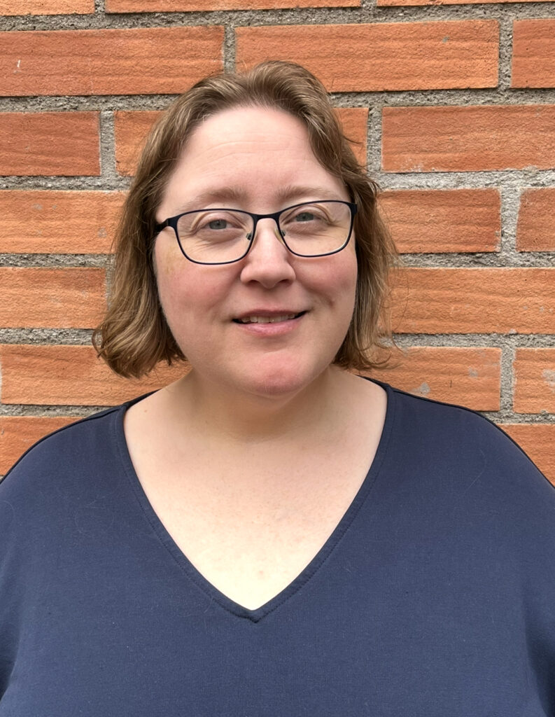 Victoria Jern Nilsson, Lokalvårdare Sofia har ljusbrunt hår som nästan räcker ner till axlarna. Hon bär glasögon och en blågrön V-ringad topp,