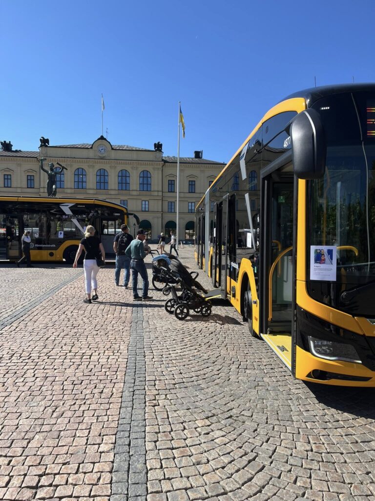 Värmlandstrafiks bussar uppställda på stora torget I Karlstad. Människor kliver in och ut för att inspektera dom.