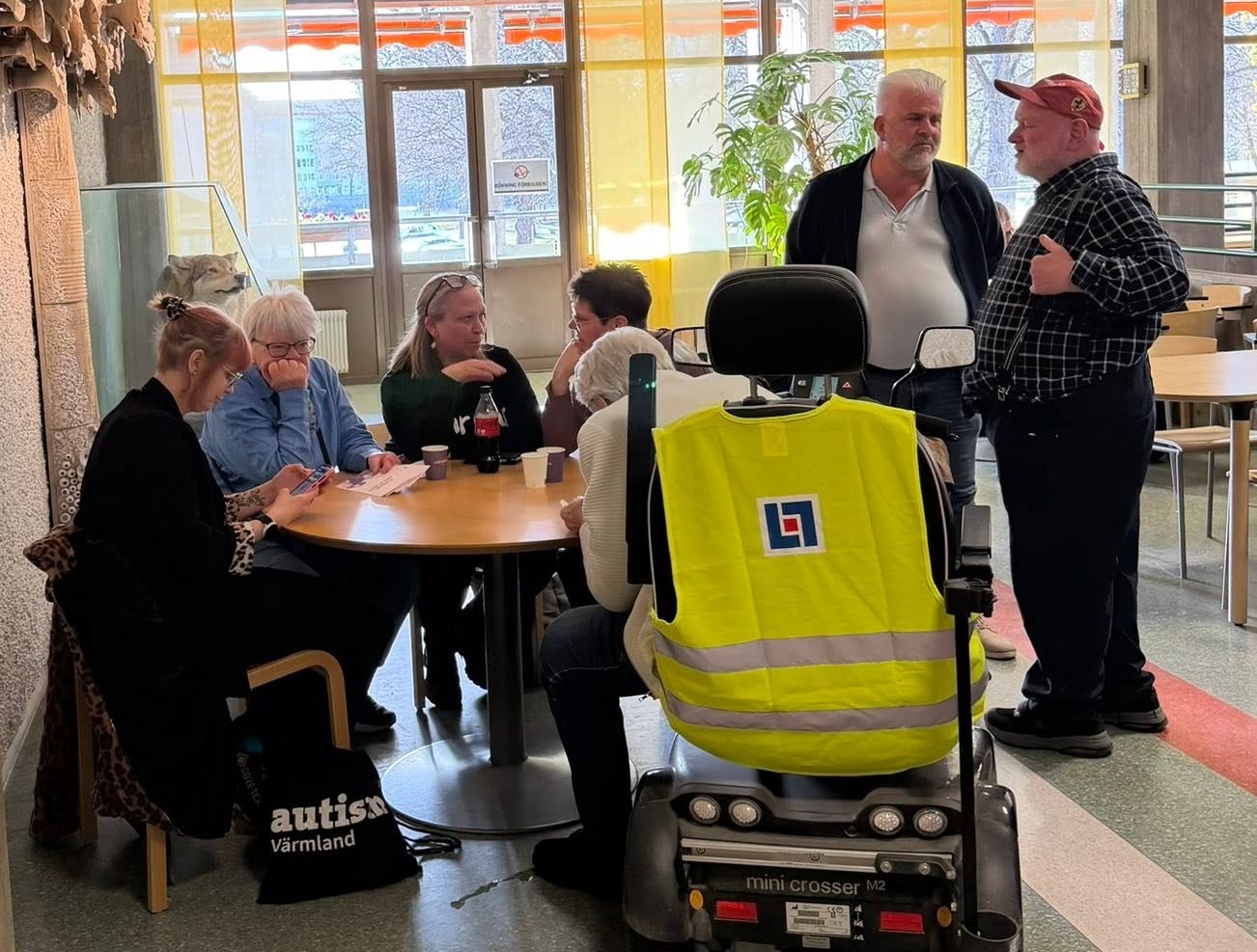 En handfull medlemmar sitter runt ett bord och samtalar med ett par regionpolitiker.